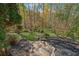 Stone steps lead to a grassy backyard surrounded by mature trees and landscaping at 220 Spring Branch Dr, Canton, GA 30115