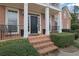 Brick front porch with black door and wrought iron railings at 139 Fairway Overlook, Woodstock, GA 30188