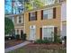 Tan two-story townhome with brown shutters and a landscaped front yard at 3003 Queen Anne Ct, Atlanta, GA 30350