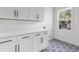 Bright laundry room features white shaker cabinets, quartz countertops, and patterned tile floor at 156 Martha Ne Ave, Atlanta, GA 30317