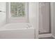Bathroom with a tub and separate shower, plus a window with blinds at 102 Rocky Branch Way, Villa Rica, GA 30180