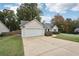 House exterior showcasing a driveway, garage, and landscaping at 102 Rocky Branch Way, Villa Rica, GA 30180