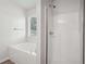 Bathroom with a tub, shower, and window that lets in natural light at 102 Rocky Branch Way, Villa Rica, GA 30180