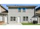 Back of a two-story home with a small patio and grassy backyard at 611 Shadow Valley Ct, Lithonia, GA 30058