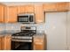 Well-appointed kitchen boasts stainless steel appliances, wood cabinetry, and granite counters at 611 Shadow Valley Ct, Lithonia, GA 30058