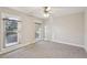 Bright bedroom with carpet, ceiling fan, and two large windows at 1431 Brandy Shoals Se Ct, Conyers, GA 30013