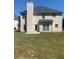 Rear view of a two-story house featuring a patio and grassy area at 2118 Water Mill Ct, Buford, GA 30519