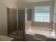 Bathroom with shower and soaking tub, featuring neutral tile at 2118 Water Mill Ct, Buford, GA 30519