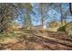 Large backyard with mature trees and a sloped lawn at 1142 Pontiac Cir, Austell, GA 30168