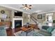 Open living room with hardwood floors, fireplace, and access to the kitchen at 21 Belmore Manor Dr, Suwanee, GA 30024