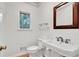 Elegant powder room with pedestal sink and wood flooring at 2548 Mercedes Ne Dr, Atlanta, GA 30345