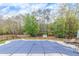 Inground pool with safety cover and wooded backdrop at 1772 Brittany Chase Nw, Kennesaw, GA 30152