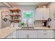 Updated kitchen featuring white cabinets, granite countertops, and floating shelves at 1485 Ryan Sw St, Atlanta, GA 30310