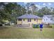 Back of house showcasing yellow siding and a patio with a stone retaining wall at 1778 Campbellton Sw Rd, Atlanta, GA 30311