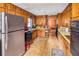Retro kitchen with wood cabinets, appliances, and vinyl flooring at 1778 Campbellton Sw Rd, Atlanta, GA 30311