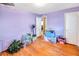 Bedroom with lavender walls, hardwood floors, and storage boxes at 1778 Campbellton Sw Rd, Atlanta, GA 30311