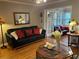 Living room with black leather sofa and sunroom access at 98 De Arc Nw, Atlanta, GA 30327