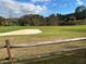 Partial view of a golf course with sand trap and wooden fence at 98 De Arc Nw, Atlanta, GA 30327