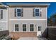 Two-story townhome with gray siding, brick base, and patio at 701 Trevett Way, Marietta, GA 30062