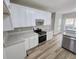 Modern kitchen with white cabinets, granite countertops, and stainless steel appliances at 2654 Calumet Farm Ln, Snellville, GA 30039