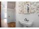 Charming half bathroom with pedestal sink and toile wallpaper at 4409 Shiloh Rd, Loganville, GA 30052