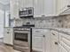 Stainless steel range and microwave in a kitchen with white cabinets at 8615 Amsbury Way, Cumming, GA 30041