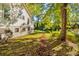 Side yard with mature trees, a leaf covered path, and lush grass at 3838 Collier Nw Dr, Atlanta, GA 30331