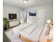 Virtually staged main bedroom with white bedding and a TV at 5876 Poplin Ct, Lithonia, GA 30058