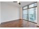 Bright bedroom featuring hardwood floors and expansive window with city views at 270 17Th Nw St # 1108, Atlanta, GA 30363
