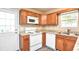 Galley kitchen with white appliances and wood cabinets at 6315 Wellington Walk Way, Lithonia, GA 30058