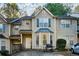 Tan two-story townhome with gray shutters and a small front yard at 6677 Sunset Hills Blvd, Rex, GA 30273