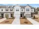 Three-unit townhome building, featuring neutral siding, gray roofs, and landscaping at 204 Kenoot Dr, Mcdonough, GA 30253