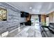 Living room with wood-paneled walls, a large TV, and access to a back patio at 4364 Saddlecreek Ct, Auburn, GA 30011