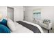Main bedroom with comfortable bed, sitting chair, and neutral color palette at 63 Black Rock Rdg, Sharpsburg, GA 30277