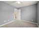 Simple bedroom with gray walls, carpet, and door to hallway at 902 Callee Dr, Loganville, GA 30052