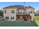 Backyard with a two-story house featuring a wooden deck and grassy area at 2420 Bronze Ct, Cumming, GA 30041