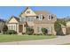 Two-story brick home with stone accents, landscaped lawn, and a paved driveway at 2420 Bronze Ct, Cumming, GA 30041