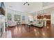 Open concept living room with fireplace, hardwood floors, and view of the kitchen at 2420 Bronze Ct, Cumming, GA 30041