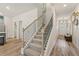 Modern staircase with gray carpet and black metal railings, leading to the upper level at 400 Brooch Way, Stockbridge, GA 30281