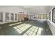 Bright sunroom with multiple windows, ceiling fans, and green carpet at 3520 Tom Brewer Rd, Loganville, GA 30052