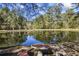 Picnic table by a tranquil pond with scenic wooded surroundings at 3520 Tom Brewer Rd, Loganville, GA 30052
