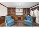Bright study with built-in wooden shelving and two armchairs at 3520 Tom Brewer Rd, Loganville, GA 30052