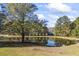 Serene pond view with house in background at 3520 Tom Brewer Rd, Loganville, GA 30052