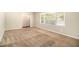 Bright living room featuring neutral walls and brown carpeting at 4257 Midway Rd, Douglasville, GA 30134