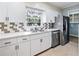 Updated kitchen features white cabinets, stainless steel appliances, and neutral countertops at 1396 Gale Dr, Norcross, GA 30093