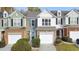 Three-unit townhome building with stone and siding, two-car garages, and landscaping at 247 Kigian Trl, Woodstock, GA 30188