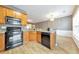 Well-equipped kitchen with wood cabinets, granite countertops, and black appliances at 247 Kigian Trl, Woodstock, GA 30188