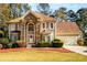 Two-story house with stone accents, a three-car garage, and manicured landscaping at 1379 Christiana Dr, Lawrenceville, GA 30043