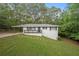 White brick ranch house with carport, black railings, and landscaped yard at 6650 Queen Mill Se Rd, Mableton, GA 30126