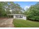 White brick ranch house with carport, black railings, and landscaped yard at 6650 Queen Mill Se Rd, Mableton, GA 30126